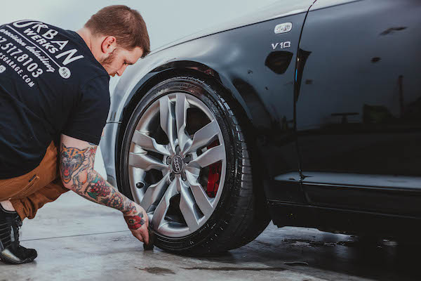 man cleans Audi S5 wheel